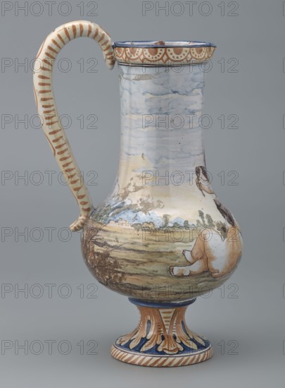 Jug on a leg, Jug with a bulging belly on a leg, with an elongated neck ending in a profiled, slightly flared spout, and an S-shaped curved cylindrical handle. On the body and neck is a painted scene with three playing cupids against a landscape with mountains and buildings. The foot and lid are decorated with plant motifs acanthus leaf. 19th century. Jug. Height 16.7 cm; diameter 9 cm; total height 26.7 cm; diameter 9 cm., A tall ceramic jug with a curved handle, shown against a plain gray background, featuring a rounded body that tapers to a narrower neck and stands on a flared foot; the jug is painted with a landscape scene in pale blues, greens, tan, brown, and cream, with a sky area in soft blue and white cloud-like brushwork, a ground area in muted greens and browns, and a seated human figure shown from the back in cream and light brown tones; the handle is cream with brown stripes, the rim and foot have decorative bands and scalloped motifs in brown, blue, and cream, and the foo...
