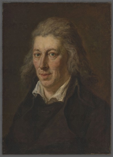 Michal Gedeon Radziwill 1778–1850, unknown author. Bust en quatre, turned slightly to the left, looking straight ahead. Ash-colored light graying hair, gray-blue eyes. Dressed in a black redingote coat with a black frock coat underneath; white shirt collar unbuttoned at the neck. Brown-olive background. Portrait, before 1850. Height 55.0 cm; width 39.3 cm., A painted portrait of a person shown from the chest up against a dark background, featuring light skin tones, grayish hair that is shoulder-length and slightly wavy, greenish eyes, and a neutral facial expression. The subject wears a dark coat or jacket over a white or off-white collar that peeks out at the neck. Visible colors include brown and dark brown in the background and clothing, gray in the hair, green in the eyes, pale pink and beige in the skin and cheeks, and white in the collar.