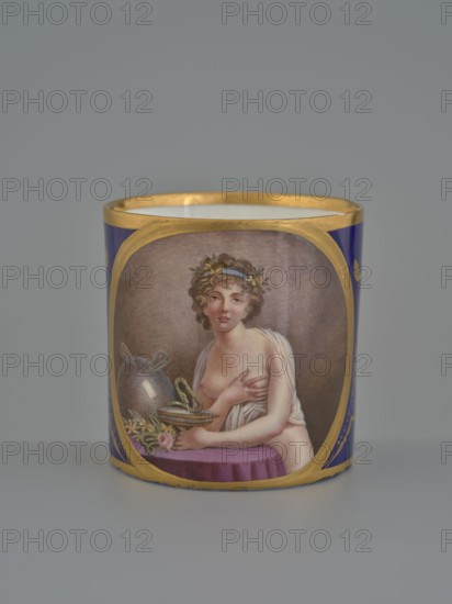 Cup, Manufacture nationale de porcelaine de Sèvres 1756–, 1803–1804, soft-paste porcelain; vessel, height 7.5 cm., A cylindrical object with a gold rim featuring a painted oval scene of a partially draped person with curly brown hair and a laurel wreath, seated behind a purple cloth and holding a shallow dish with a small coiled green snake, next to a reflective vessel and some flowers; the cylinder has deep blue sides and additional gold decoration, and the background is a neutral gray.