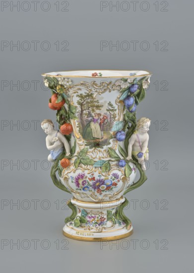 Vase, 19th/20th century, Meissen; vase; diameter 36 cm, base diameter 24 cm., A decorative porcelain vase with a rounded body and flared rim sits against a gray background, predominantly white with painted and applied multicolored ornament; a central painted scene shows a group of three people in period dress framed by gold scrollwork, and floral bouquets in purple, red, blue, and yellow decorate the lower body. Applied green leafy vines with sculpted fruits in orange and purple climb the sides, and two cherubic child figures in pale skin tones and pastel clothing cling to the vine handles. The rim and base have gold accents, and additional small painted flowers appear inside the rim and on the pedestal, with the overall color palette including white, green, gold, orange, purple, blue, red, and yellow.