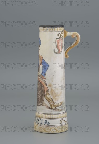 Mug. Maker: Jadwiga Hyzycka 1856–1922, Majolica Manufactory in Nieborów manufacturer, 1881–1899. Cylindrical mug, slightly tapering toward the top, with a handle. Mantle decorated with an image of a nobleman sitting on a barrel holding a glass goblet in his right hand; a coat of arms next to the handle; plant decoration. Inscription on the pedestal: Hulaj dusza. Date: 1881–1890. Tankard. Dimensions: height 28 cm; width 15 cm with handle; inlet diameter 6.5 cm; bottom diameter 9 cm., A tall cylindrical ceramic mug with a curved handle features painted decorative motifs and a partial figure. The mug's main body is off-white with hand-painted accents in blue, brown, yellow, pink, black, and green. The handle is yellowish with brown shading. Near the top rim is a band with black and yellow striping and a small ornate pink and green shield-like motif. The painted figure shows a person wearing a blue sleeve, brown outer garment, and yellowish boots, seated beside a large brown wheel. The bas...
