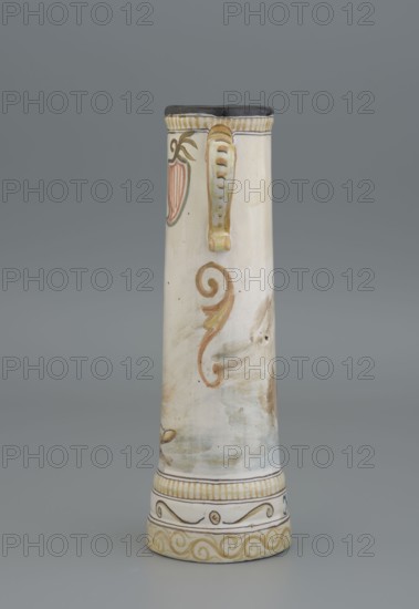 Mug. Painter: Jadwiga Hyzycka 1856–1922. Manufacturer: Majolica Manufactory in Nieborów 1881–1899. Cylindrical mug, slightly tapering toward the top, with a handle. Mantle decorated with an image of a nobleman sitting on a barrel holding a glass goblet in his right hand. Coat of arms next to the handle. Plant decoration. Inscription on the pedestal: Hulaj dusza. Date: 1881–1890. Place of origin: Nieborów Michal Piotr Radziwill's Majolica Manufactory. Tankard; height 28 cm, width 15 cm with handle, inlet diameter 6.5 cm, bottom diameter 9 cm., A tall cylindrical ceramic vessel with a narrow top and wider base standing against a gray background, primarily cream and off-white in color with visible brushy areas of light brown and pale blue, decorated with a curved handle painted in yellow and brown attached near the top, a painted ornamental swirl in brown and muted green on the body, a stylized red and brown leaf-like motif near the top, and bands of decorative patterns in yellow and brow...