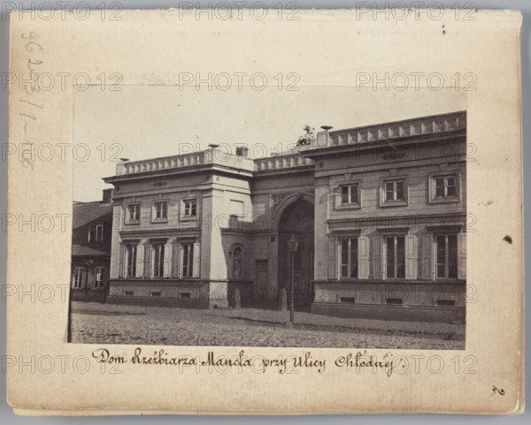 The Sculptor Manzel's House at Chlodna Street View of the front elevation of the house built for Jan Józef Manzel, Beyer, Karol 1818–1877 photographer/author; Manzel, Jan Józef 1806–1875 subject; Méyet, Leopold 1850–1912. Tenement houses; iconography of Jan Józef Manzel. Warsaw, Chlodna Street. Photography, nature photography. Photographic print: image height 5.8 cm, image width 8.8 cm; support height 11.3 cm, support width 8.8 cm. 1861–1863., A sepia-toned photograph shows a classical two-story building with a central arched entrance flanked by two symmetrical wings, each featuring tall rectangular windows with shutters and decorative cornices; the facade includes pilasters, a balustrade along the roofline, and a sculptural element visible atop the center ridge. The building sits behind a cobblestone street with a lamppost in front, and a smaller adjoining structure is partially visible to the left. The image palette includes shades of brown, beige, cream, gray, and muted black.