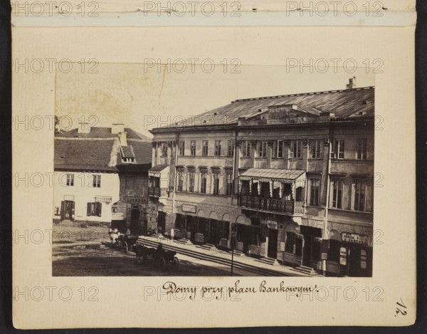 Warsaw. Houses at Bankowy Square View from the Polish Bank building on the Kossecka tenement house at Bankowy Square, corner of Zabia Street, Beyer, Karol 1818–1877 author, tenement houses, Warsaw Masovian Voivodeship, Bankowy Square Warsaw, Senatorska Street Warsaw, Zabia Street Warsaw, beer, signboards, currency exchange offices, Kossecka tenement house Warsaw; Bankowy Square, 1861–1863, Warsaw place of creation, photography, nature photography, photographic print: height 6 cm, width 9 cm, backing: height 11.3 cm, width 8.8 cm, A sepia-toned photograph mounted on a cream-colored page showing a street scene with a group of adjacent multi-story buildings with rectangular windows and a variety of architectural details; one building has a covered balcony with ornate railing and fringe, and the roofs are pitched and metal or shingled. In front of the buildings a few horse-drawn wagons and horses stand on a dirt or cobbled street area, and there are a few indistinct figures near the wagons...