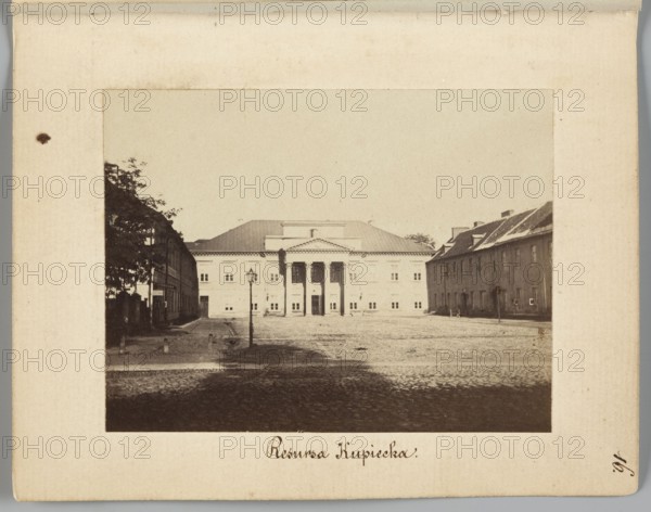 Resursa Kupiecka Former Mniszech Palace at Senatorska Street, Mniszech Palace Warsaw, Warsaw Masovian Voivodeship; Beyer, Karol 1818–1877 photographer/creator; Méyet, Leopold 1850–1912 author; cobblestones, street lamps, Senatorska street; 1861–1863; photography, nature photography; photographic print: height 6.2 cm, width 8 cm; backing: height 11.3 cm, width 8.8 cm., A sepia-toned photograph mounted on a light beige board shows a wide cobblestone square flanked by buildings, with a large classical building centered in the background featuring a triangular pediment and columns at its entrance; a tall street lamp stands near the middle foreground, and a few trees and two rows of lower buildings frame the square on the left and right. The visible colors are beige, brown, dark brown, and off-white.