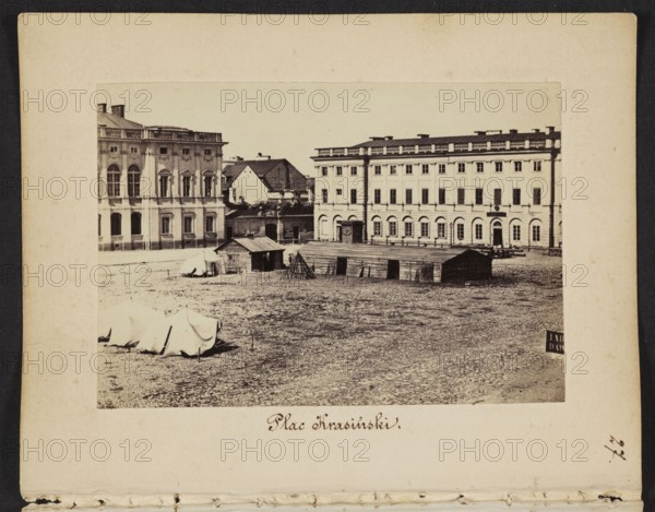 Warsaw. Krasinski Square View of the square with a fragment of the Krasinski Palace designed by Tylman van Gameren and the palace annex designed by Christian Piotr Aigner, Karol Beyer 1818–1877 photographer/author; military tents, Russian army, gates, wooden barracks, pavement, annexes; Aigner, Christian Piotr 1756–1841 - iconography; Tylman van Gameren c.1629–1706 - iconography; 1861–1863; Warsaw Masovian Voivodeship; photography, nature photography; photographic print: height 6 cm, width 8.6 cm; support: height 11.4 cm, width 8.8 cm., A sepia-toned photograph mounted on a beige card showing an open cobblestone square with a few low wooden sheds and a couple of canvas-covered structures in the foreground, framed by large multi-story classical buildings with rows of windows and decorative facades in the background; the visible colors are shades of brown, beige, cream, and black.