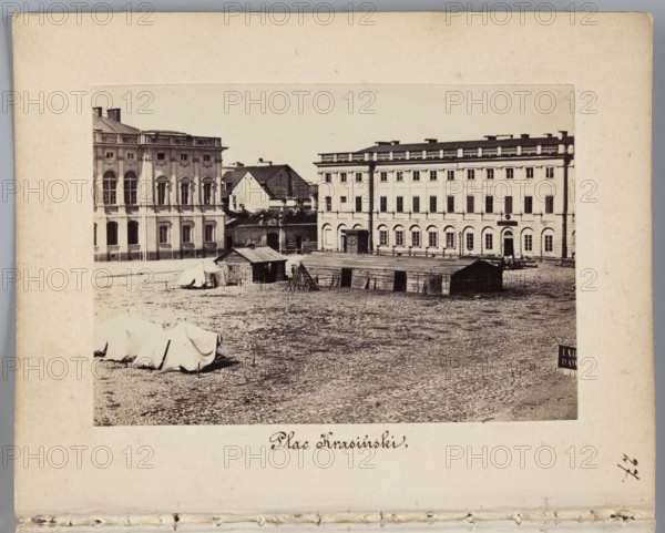 Krasinski Square View of the square with a fragment of the Krasinski Palace designed by Tylman van Gameren and the palace annex designed by Christian Piotr Aigner, photographer: Karol Beyer 1818–1877; subjects: military tents, Russian army, gates, wooden barracks, pavement, annexes; people/architects depicted/iconography: Christian Piotr Aigner 1756–1841, Tylman van Gameren ca. 1629–1706; date: 1861–1863; place: Warsaw Krasinski Square, Masovian Voivodeship; medium: photography, photographic print image: 6.0 × 8.6 cm; support: 11.4 × 8.8 cm; genre: nature/urban photography., A sepia-toned photograph shows an open cobblestone square with a few simple wooden structures and tents arranged across the middle ground. Behind them are two large multi-story classical buildings with rows of tall windows and decorative facades; one building appears lighter and the other slightly darker in tone. In the foreground the cobbles and ground texture are visible. Colors present include sepia brown, beige...