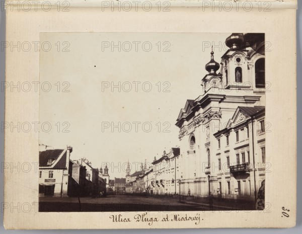 Dluga Street from Miodowa Street View towards Freta Street, Karol Beyer 1818–1877 author, Orthodox churches, Pauline Church Warsaw; Freta Street, Dluga Warsaw; street, Warsaw Masovian Voivodeship, St. Jacek Church Warsaw; Freta Street, Freta Warsaw; street, Piarist Church Warsaw; Dluga Street, St. Trinity Warsaw; Dluga Street, 1861–1863, Warsaw place of creation, photograph, photograph from nature, photographic print: height 7 cm, width 8.8 cm, support: height 11.4 cm, width 8.8 cm, A sepia-toned photograph shows a street scene with a group of multi-story buildings lining the right side and a group of smaller buildings along the left, leading toward a distant cluster of towers. The right-side buildings include a large ornate structure with domes and decorative architectural details, and adjacent simpler facades with windows and balconies. The left-side buildings have pitched roofs and smaller windows. The street in the foreground appears open and mostly empty, with a few indistinct fig...