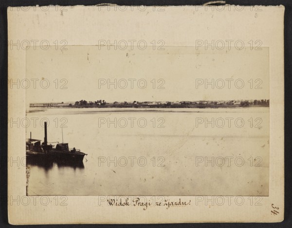 View of Praga from Zjazd View from Nowy Zjazd on the Praga bank of the Vistula, Karol Beyer 1818–1877, photographer; Leopold Méyet 1850–1912 – visual documentation; 1860; Warsaw; Praga district on the Vistula; photography, nature photography; photographic print: height 6.2 cm, width 9.5 cm; support: height 11.4 cm, width 8.8 cm., A sepia-toned photograph mounted on a beige board shows a wide calm body of water filling most of the frame, with a dark silhouette of a moored boat visible along the left edge, its smokestack and small structures rising above the deck and a soft reflection in the water below; a low distant shoreline runs horizontally across the image with a few clustered dark tree shapes and low buildings against a pale sky, and the surrounding mounting shows off-white and cream borders with slight discoloration and worn edges.