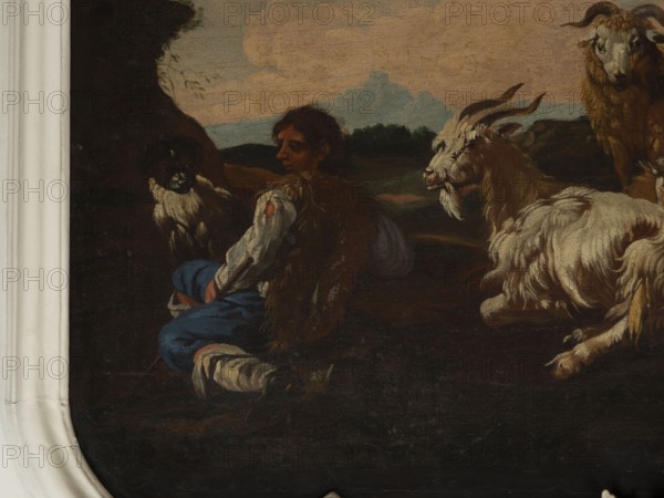 Shepherd Scene with a View of the Castle, Roos, Philipp Peter 1657–1706. Multicolored composition with dominant shades of brown against a blue sky with white clouds and a distinct pink glow. In the foreground, the central group consists of two goats, a male and a female, lying down, with a male goat standing behind them. On the left, a slope, a dog, and a shepherd sitting in half-profile, wearing a brown sheepskin coat, blue trousers, a white shirt, and stockings. On the right, in the background on a hill, two cylindrical buildings and behind them castle buildings. 18th century, Italy; overdoor; height 92.0 cm, width 115.0 cm., A dark-toned painting fragment showing a seated person with brown hair wearing a white-sleeved garment, a brown fur-like vest, and blue trousers, positioned near a group of goats; one goat with long curved horns and shaggy white and beige fur faces toward the seated figure, another goat with similar coloring lies nearby, and a darker-faced goat with lighter fur ...