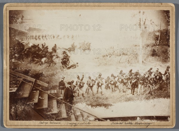 Painting the Raclawice Panorama: Teodor Axentowicz standing on scaffolding by a section of the canvas depicting a battle scene of the company of Józef Wodzicki’s 2nd Infantry Regiment; photographic print photography from nature, glued to cardboard backing; 1893/1894; image height 11.9 cm, width 17.3 cm pad 13.5 × 18.5 cm. Depicts painters and painting accessories, scaffolding, and artists' studios; related to the Panorama of the Battle of Raclawice by Wojciech Kossak and Jan Styka; Teodor Axentowicz 1859–1938, Wojciech Kossak 1856–1942, Jan Styka 1858–1925., The image shows a sepia-toned scene with a group of soldiers in uniform standing and marching on grassy terrain, a group of mounted cavalry in motion with horses and riders to the left, and a few figures in civilian clothing near wooden structures or steps in the lower left. The background includes trees and open ground, and the overall colors visible are shades of brown, tan, beige, and off-white.