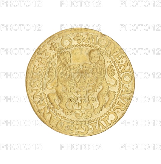 Gdansk ducat, Stefan I Batory king of Poland; 1575–1586, author; Gdansk, Poland; coin, A circular gold-colored coin shown against a white background, featuring a raised ornate central design with a symmetrical heraldic emblem flanked by two stylized animals, decorative flourishes and a beaded inner rim; the outer field contains raised lettering and small decorative motifs around the edge.