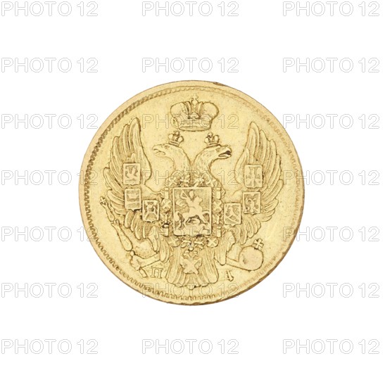 3 rubles = 20 zlotys; Nicholas I Pavlovich Tsar of Russia; reign 1825–1855 creator; St. Petersburg mint; coin., A circular metallic object with a textured rim, shown against a white background, featuring an embossed double-headed eagle with outstretched wings and a central shield; the eagle wears crowns and holds ornate elements near its talons, with additional small decorative shields and motifs arranged on and around the wings. The surface shows a metallic sheen and fine engraved details. The visible colors are gold and shades of light brown or beige from the metal and its shadows.