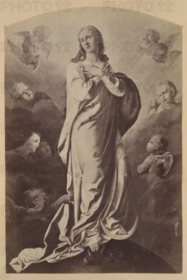 Photograph of a painting: Ignacy Jasinski 1833–1878, Immaculate Conception, from the church in Nowe Miasto nad Pilica, 1876; Ignacy Jasinski 1833–1878, Polish painting; reproduction, religious painting, Immaculate Conception iconography; Nowe Miasto nad Pilica Masovian Voivodeship; print glued across the entire surface to the recto page of the 15th album page, ca. 1880; photograph of a work of art; photograph in an album; height 23.4 cm, width 15.6 cm., A tall, robed female figure stands centrally on a rounded dark surface with her hands crossed at her chest, wearing flowing garments with visible folds and drapery in shades of beige and gray; her hair is long and falls over her shoulders, appearing darker than her clothing. Surrounding her are a group of cherubic faces and small winged figures emerging from cloud-like formations in tones of gray and muted cream, some looking toward the central figure. In the lower foreground an infant-like figure with small wings looks upward from a cl...