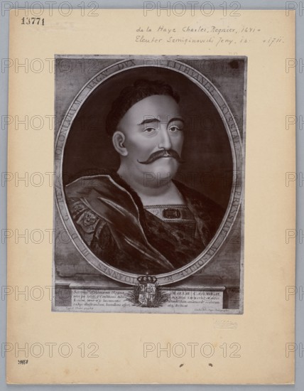 Photograph of a copperplate engraving: Charles de La Haye 1641–post 1712 and Jerzy Siemiginowski-Eleuter ca. 1660–1711, portrait of Jan III Sobieski King of Poland; 1629–1696. Photographer: Boleslaw Julian Sztejner 1861–1921. Subjects and attributes: personalities; Polish personalities; Polish royal dynasties; Polish princely families; kings; Jan III Sobieski — iconography; Aleksander Kraushar 1843–1931; Charles de La Haye; Jerzy Siemiginowski-Eleuter — reproduction. Medium: print glued to cardboard photographic studio. Date: before 1915. Place of origin: Wloclawek . Object type: photograph of a work of art, photographic print. Dimensions: photographic print H 22.5 cm × W 16.5 cm; support H 35 cm × W 25 cm., An oval-framed black-and-white portrait of a man with pale skin, dark hair, and a dark mustache, shown from the chest up and turned slightly to one side; he wears a dark, velvety cloak with visible folds and a textured garment underneath, including a decorative rectangular ornament...