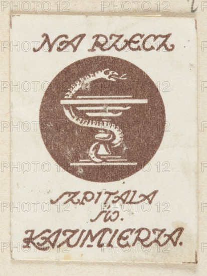Depicting the chalice of Hygieia and the inscription: FOR THE SAINTS OF ST. CASIMIER'S HOSPITAL; unknown creator; charity; Poland; World War 1914–1918; 20th century; charity stamps; health service; Radom Masovian Voivodeship; 1917; Radom; print; ephemera., A rectangular off-white card with a faded brown circular emblem in the center depicting a coiled snake-like form entwined around a horizontal bar and a small pedestal-like shape, surrounded by decorative brown script above and below the circle; the card shows light stains and aged discoloration with tones of beige, cream, brown, and small darker specks.