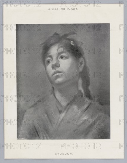 Reproduction of a painting: Anna Bilinska-Bohdanowicz 1857–1893, Studjum; photographer: BW fl. ca 1915. Painting; Polish painting; portrait of a girl; portraits; early 20th century; press illustration; reproduction of a work of art., A grayscale portrait of a young person shown from the shoulders up, with a soft, painterly texture and subtle tonal shading; the subject's head is tilted slightly and eyes gaze upward and to the side, with a calm, contemplative facial expression; hair is dark and pulled back with a small floral accessory visible, and a few loose strands frame the face; clothing appears draped and softly rendered around the shoulders and neck; the image is centered on a light background with a narrow border surrounding the portrait; visible colors are shades of gray, black, and white.