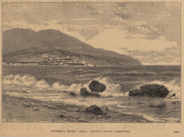 Crimean coast: Yalta; woodcut after a painting by Feliks Brzozowski 1836–1892; illustration published 1889; subject: Yalta, Crimea — Black Sea city view / seaside landscape; technique: graphics/woodcut; style: Polish painting; reproduction., A coastal scene showing a shoreline with waves breaking against several dark rocks in the foreground, a stretch of water with ripples and white foam extending toward a distant town along the coast, a cluster of low buildings and structures at the water’s edge, and a range of hills or mountains rising behind the town under a cloudy sky; the image appears in muted tones of beige, brown, and dark gray.