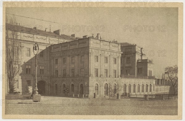 Warsaw. Royal Castle, photographer Jan Bulhak 1876–1950; co-author: St. Wojciech's Printing House and Bookstore Poznan; publisher: Polish Society of Railway Bookstores Ruch; subject: Royal Castle Warsaw, Castle Square, Warsaw Masovian Voivodeship; ca. 1930; postcard; 9 cm × 14 cm., The image shows a large classical building with multiple stories and arched ground-level openings, rendered in sepia tones of brown and beige; a paved open area in front leads to the facade, where a tall ornate street lamp stands on a stone base near a few bare trees; the building features rows of rectangular windows, decorative cornices, and flat rooflines with small rooftop structures, and a low railing or balustrade runs along part of the upper level; to the right, a smaller attached structure and a group of trees are visible, all depicted in muted brown and tan hues.