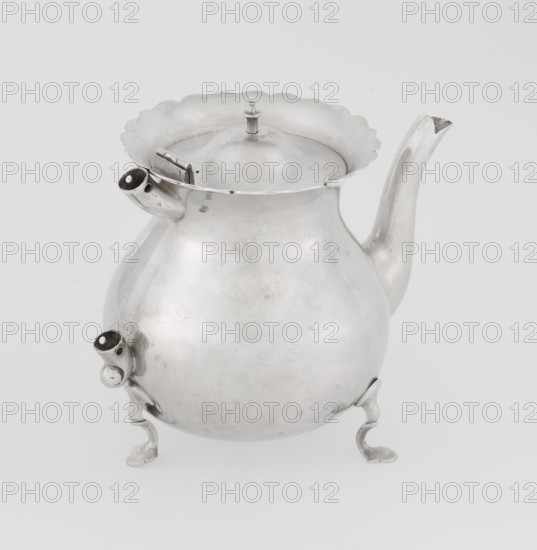 Teapot, Stokes & Ireland Ltd Birmingham; goldsmiths; fl. 1872–1925. Pear-shaped teapot supported on three legs, smooth, with a flared upper edge topped with a pinnacle, with a spout-shaped spout, on the axis silver bushings for mounting the missing wooden handle. 1900–1901. Great Britain; England; Chester. Vessel. Height 11.5 cm, width 15.5 cm, depth 10 cm, weight 330 g., A rounded metal teapot with a reflective silver surface sits against a plain light gray background, showing a curving spout on one side and a short angled spout on the opposite side, a scalloped rim around the lid, a small finial on top of the lid, and a hinged section near the rim; the teapot rests on a few curved decorative feet and displays areas of slight tarnish and subtle surface texture in silver and gray tones.