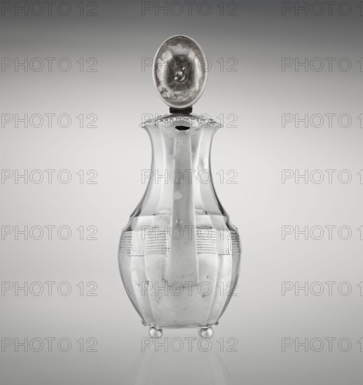 Coffee pot, maker: Harris, CS & Sons London; goldsmiths' firm; fl. 1817–1933 and Harris, Charles Stuart fl. 1852–1897. Purchased, Silver coffee vessel, ribbed, pear-shaped, supported on four ball-shaped profiled legs; belly decorated with a band of narrow half-cylinders and grooves. High spout-like side handle and a contemporary wooden axial handle set in silver sockets. Upper edge edged with a godron band; hinged lid, domed center, topped with a bowling-pin finial. Dated 1895–1896. Place: London, England. Dimensions: height 21.2 cm; width 18.5 cm; depth 10 cm; weight 640 g., A metallic pitcher with a hinged oval lid open upward, showing a reflective inner surface; the pitcher has a tall, slender neck that flares at the rim, a broad handle running down the front, a rounded body with horizontal ribbed bands near the upper section, and rests on a few small rounded feet. Visible colors include silver, gray, and subtle darker gray reflections against a gradient gray background.