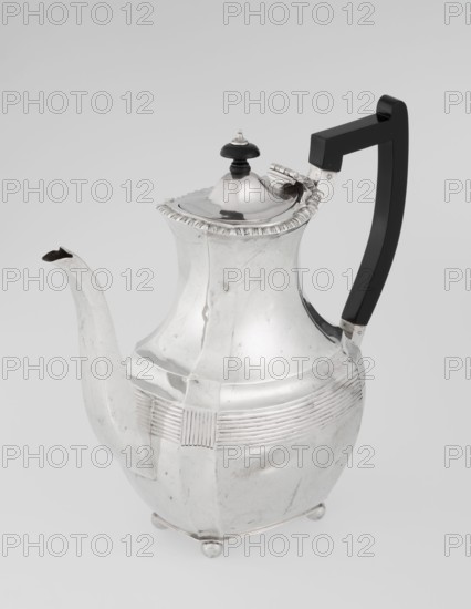 Coffee pot by Harris, CS & Sons London; goldsmiths' firm, fl. 1817–1933 and Charles Stuart Harris maker, fl. 1852–1897. Scrap-purchased; ribbed, pear-shaped silver coffee vessel supported on four ball-shaped profiled legs. Belly decorated with a band of narrow half-cylinders and grooves; godron ornaments; high spout-shaped handle on the side with a contemporarily added wooden axial handle set in silver sockets. Upper edge edged with a godron band; hinged lid domed in the center, topped with a bowling-pin finial. Dated 1895–1896. Made in London, Great Britain. Height 21.2 cm; width 18.5 cm; depth 10 cm; weight 640 g., A silver teapot with a polished surface showing reflections, a curved spout, a hinged domed lid topped with a small black finial, and an angular black handle attached at the back; the body has horizontal ridged decoration around its midsection, a flared rim with a scalloped edge, and rests on small rounded feet. Colors visible include silver, black, and shades of gray from...