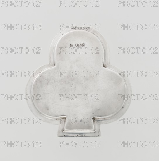 Tray, Hukin & Heath Birmingham; London; goldsmiths' firm; fl. 1855–1953 maker, Heath, John Thomas & Middleton, John Hartshorne makers, club-shaped tray with a smooth mirror surrounded by a raised half-cylinder with an edge decorated with an ornament of diagonal godrons; godron ornaments; scrap; 1897/1898; Great Britain, England, London; table accessory; height 1.1 cm, width 12.5 cm, depth 11.9 cm, weight 86 g., A metallic object with a smooth, slightly scuffed surface in a pale silver color, shaped like a rounded trefoil with a short rectangular tab at the bottom; the metal shows a few fine scratches and subtle darker smudges, and the object sits against a plain light gray background.