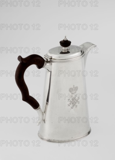 Conical coffee pot with hinged lid, slightly arched and flattened at the top, topped with a wooden handle made; short spout on the axis with two sleeves for attaching a wooden handle added contemporarily. Engraved mantle monogram tied HH beneath a ducal mitre; dated 1890/1891. Maker: Barnard, Edward & Sons Ltd London, goldsmiths, fl. ca. 1680– ; sold by Clark, Alfred Ltd London, goldsmiths and sellers, fl. 1898–1934. Materials: silver with wooden handle. Function: coffee ware. Place: Great Britain — England, London. Dimensions: height 17.3 cm, width 11 cm, depth 8.4 cm; weight 627 g., A tall, tapered metal pitcher with a reflective silver surface and a polished lid topped by a dark brown knob, featuring a curved spout and a hinged lid; a dark brown, carved wooden handle with visible grain attached to the side by silver fittings; overall colors visible include silver and dark brown, set against a light gray background.