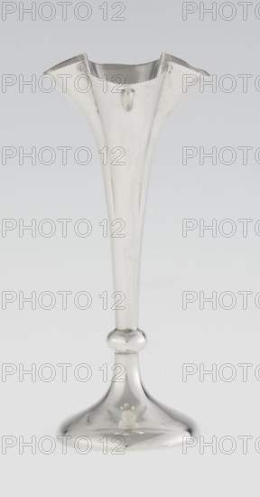 Chalice-shaped vase by Woodward, Horace & Co Ltd Birmingham, London; fl. ca. 1851–1919. Maker's role: goldsmith's firm. Inscription/classification: corporate slogans. Purchase, Scrap-purchase. Vessel decorated with flowers; pearling ornament. Vase supported on a circular foot transitioning into a short stem terminating in a ring; goblet in the form of a slender flower calyx, tall conical, quarter-part at the top, edged with pearling. Date: 1899–1900. Place: Great Britain, England, London. Object type: vessel. Dimensions: height 12.5 cm; width 5.5 cm; depth 5.5 cm; weight 38 g., A tall metallic object shaped like a slender trumpet or vase with a flared, scalloped top and a rounded base, shown against a light gray background; the object appears shiny and reflective with a silver color and shows subtle surface marks and highlights in tones of white and gray.