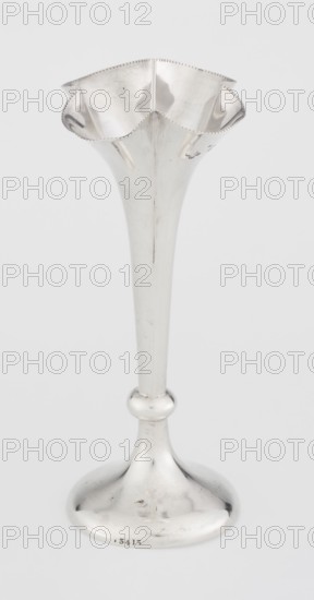 Chalice-shaped vase, maker: Woodward, Horace & Co Ltd Birmingham, London; fl. ca 1851–1919, maker's role, goldsmith's firm; materials/technique: not stated; subject/decoration: flowers vessel, pearling ornament; form: vase supported on a circular foot transitioning into a short stem terminating in a ring, with a goblet in the form of a slender flower calyx, tall, conical, quarter-part at the top, edged with pearling; date: 1899/1900; place: Great Britain, England, London; function: vessel; dimensions: height 12.5 cm, width 5.5 cm, depth 5.5 cm; weight: 38 g., A tall slender metallic vase with a flared, ruffled rim sits against a light background, the vase showing a reflective silver surface with highlights and subtle darker smudges and scratches, a rounded bulbous knop about midway down the stem, and a gently curved circular base that mirrors the surrounding tones.