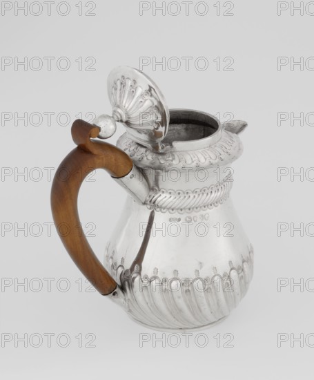 Coffee pot by John Septimus Beresford London goldsmith, active 1880–89. Pear-shaped jug, spirally clacked in the lower part, smooth above, decorated with a half-cylinder under the upper flared rim; short spout-shaped spout; wooden handle not original mounted in sleeves; hinged domed lid, spirally knotted, topped with a ball. Dated 1888–1889, Great Britain — England, London. Vessel. Height 13 cm, width 12 cm, depth 6.8 cm, weight 179 g., A metal pitcher with a curved wooden handle attached to its side, the metal surface is shiny and reflective with ornate fluted and scalloped decorative ridges around the body and rim, a hinged domed lid with embossed fan-like pattern is open and connected near the handle, the interior of the pitcher appears darker, and visible colors include silver on the metal and brown on the wooden handle, set against a light gray background.