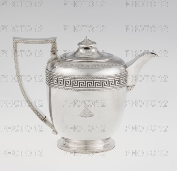 Teapot by John Emes fl. 1796–1808, English silver, c. 1806–1807. Ovoid teapot on a circular base with lid; decorated on the upper part of the belly with a wide band of meander ornament and braid. Side handle ribbon-shaped and broken in design, decorated with braid. Spout set high, decorated at the base with a stylised palmette. Lid finished with a knob-shaped handle. Belly engraved with a coat of arms on one side and a cross on the other. Empire/George III/Georgian style. Materials/technique: silver; function: tea vessel. Dimensions: height 17.9 cm, width 23.7 cm; weight 815 g. Made in London, England., A polished metal teapot with a curved spout and a tall angular handle sits against a light gray background; the body is rounded with a slightly stepped circular base and a domed lid topped by a small finial. The teapot surface shows an engraved band of geometric and braided patterns around the upper rim and decorative engraving on the lid and handle, and a simple engraved emblem on the ...