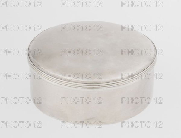 Toilet box by Edward Fernell fl. 1779–1796?, goldsmith; round, smooth with a slightly domed lid edged with a profiled band; Georgian/Classicism/George III style; 1792–1793, London, England, Great Britain; function: container/toilet accessories; height 4.2 cm, diameter 8.2 cm, weight 115 g., A round metal container with a smooth domed lid and slightly raised concentric ridges near the rim, showing a metallic silver surface with subtle variations in tone and faint marks; the background is a pale off-white.