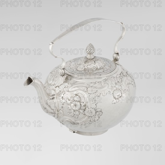 Buliera kettle for boiling water, maker: Benjamin Gignac fl. 1745–1774, goldsmith. Rocaille ornament; Rococo style with Georgian/George II influences. Spherical buliera with flat bow mounted on volutes; lateral spout-shaped spout; centrally arched cover topped with a pine cone. Decorated overall with repoussé rococo decoration and floral/plant ornaments. Two engraved coats of arms: one four-field shield in an oval beneath a baronial crown, the second in an illegible shield. Missing base with heater. Dated 1753/1754, London, England, Great Britain. Vessel. Height 22 cm, width 24 cm, depth 19 cm, weight 848 g., A round metal teapot with an ornate raised handle and curved spout, shown against a plain light background; the teapot surface features intricate floral and scroll embossing across its body and lid, with a textured finial on top shaped like a pinecone; the metal appears shiny and silvery with highlights and subtle gray reflections, and the background shows shades of pale gray and ...