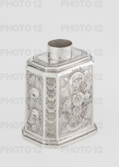 Tea caddy by Nash, Bowles fl. 1720–ca.1725, goldsmith; rococo style. Cuboid tea caddy with circular domed lid and a bowl on top; chamfered side edges; movable slide-in bottom. Surface decorated with repoussé floral and rocaille motifs on a grained background; front has an oval rocaille cartouche topped with an eagle containing engraved inscription KENNETH Mc LEOD, / to his much loved Sister / ANNE ZABA, / Octr 23 rd 1848; back wall with a bouquet of flowers; side walls with blooming, leafy roses. Engraved A on the bottom. Dates: 1723/1724 tins; ca. mid-19th century decoration. Place of origin: London, England, Great Britain. Function: vessel for loose-leaf tea; materials: tins. Dimensions: height 12 cm, width 7.7 cm, depth 5.7 cm; weight ca. 230 g., A silver metal container with an octagonal shape and a short cylindrical neck sits against a plain light gray background; the sides display ornate engraved floral and leaf patterns with raised decorative borders and textured panels, and the...