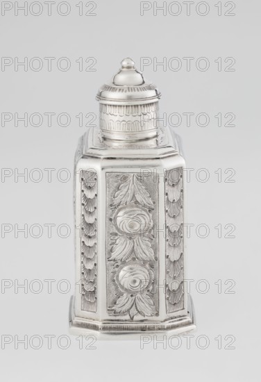 Tea caddy, Nash, Bowles fl. 1720–ca. 1725 goldsmith; rococo; tea accessory. Cuboid tea caddy with a circular domed lid and a bowl on the top; chamfered side edges; movable slide-in bottom. Surface decorated with repoussé floral and rocaille motifs on a grained background; front with an oval rocaille cartouche topped with an eagle, engraved inscription inside: KENNETH Mc LEOD, / to his much loved Sister / ANNE ZABA, / Oct 23 rd 1848; back with a bouquet of flowers; sides with blooming, leafy roses. Engraved S on the bottom; 1723/1724 tins; decoration ca. mid-19th century; London, England, Great Britain. Vessel. Height 12 cm; width 7.7 cm; depth 5.7 cm; weight ca. 230 g., A decorative metal container with a domed lid sits against a plain background, shown in metallic silver tones with lighter highlights and subtle darker shadows; the container has an octagonal or faceted body with carved or embossed floral and leaf motifs on its panels, including raised rosette shapes and textured backgr...