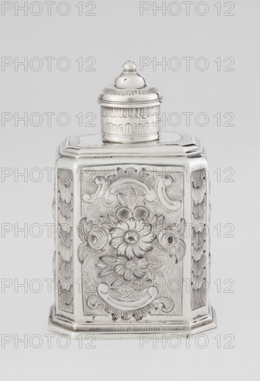 Tea caddy, Nash, Bowles fl. 1720–ca. 1725 goldsmith; rococo; tea accessory; cuboid tea caddy with circular domed lid and a bowl on top; chamfered side edges; movable slide-in bottom. Surface decorated with repoussé ornament of floral and rocaille motifs on a grained background; front features an oval rocaille cartouche topped with an eagle, with engraved inscription inside: KENNETH Mc LEOD, / to his much loved Sister / ANNE ZABA, / Oct 23rd 1848; back shows a bouquet of flowers; sides show blooming, leafy roses. Engraved S on the bottom; 1723/1724 tins; ca. mid-19th century decoration. London, England, Great Britain. Vessel. Height 12 cm; width 7.7 cm; depth 5.7 cm; weight ca. 230 g., A silver-colored metal container with a removable lid sits against a light gray background, showing an octagonal or multi-sided shape with ornate engraved floral and scrollwork designs on its front and sides; the lid is domed with concentric decorative bands and a small rounded finial on top, and the body...