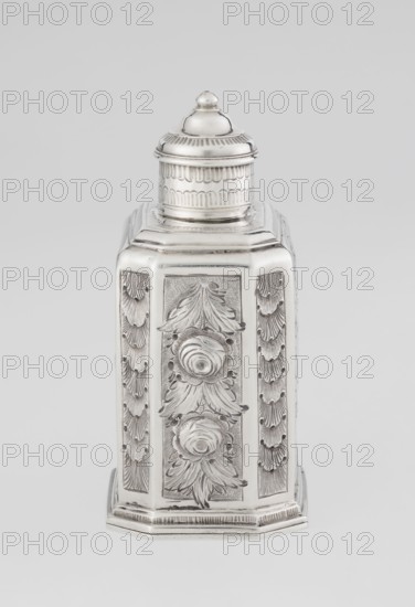 Tea caddy, Nash, Bowles fl. 1720–ca.1725 goldsmith; rococo style; tea accessory; cuboid tea caddy with circular domed lid and a bowl on top; chamfered side edges; movable slide-in bottom. Surface decorated with repoussé floral and rocaille motifs on a grained background; front with oval rocaille cartouche topped by an eagle, engraved inscription inside: KENNETH Mc LEOD, / to his much loved Sister / ANNE ZABA, / Oct 23rd 1848; back with bouquet of flowers; sides with blooming, leafy roses. Engraved S on the bottom; 1723/1724 tins; ca. mid-19th century decoration. Made in London, England, Great Britain. Vessel. Height 12 cm; width 7.7 cm; depth 5.7 cm; weight ca. 230 g., A metallic object with a tall hexagonal form and a domed lid, shown against a light gray background, finished in a reflective silver tone with engraved decorative panels featuring floral and leaf motifs, scalloped textured borders, and a stepped base; the lid has horizontal patterned bands and a rounded finial, and the o...