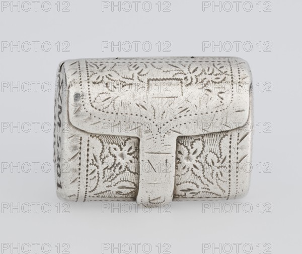 Fragrance container vinaigrette, maker: Thomas Shaw fl. 1822–ca. 1840; 1782–1845, goldsmith. Vinaigrette in the form of a bag with an envelope closure and a protruding tongue; front decorated with dot-engraved flowers and leaves. Hinged lid opening to an interior openwork insert decorated with plant scrolls. Materials/technique: engraving, openwork. Date: 1834/1835. Place: Birmingham, England, Great Britain. Function: toilet accessory. Dimensions: height 2.1 cm, width 1.5 cm, depth 1 cm; weight 10 g., A small rectangular metal box with rounded edges and an attached flap closure, covered all over in incised decorative patterns including dotted lines and floral and geometric motifs; the surface shows scratches and areas of wear. The visible colors are silver and gray, with subtle darker gray tones in the carved recesses.