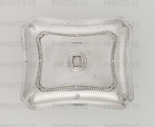 Four-sided platter by Bradbury, Thomas & Sons Sheffield; goldsmiths; fl. ca. 1769–1943. Four-sided platter with slightly concave, raised sides; upturned, irregularly cut rim, decorated with a band of godron ornament. Engraved on the side with a rooster standing on a crown. Dated 1903/1904, London, England, Great Britain. Dish. Height 3.9 cm; width 25 cm; depth 20.8 cm; weight 684 g., A rectangular metallic lid with rounded, scalloped corners and an indented central area, featuring a raised circular opening at the center and a decorative twisted rope-like border framing the inner panel; the surface shows subtle scratches and faint tarnish spots. The visible colors are silver, light gray, and darker gray tones in the worn areas.