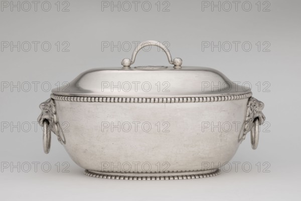 Vase with cover and platter; maker: Marcin Holke fl. ca. 1765–ca. 1792, goldsmith; tableware elements, vases; 18th century; Poland, Warsaw; vessel; height 20 cm, width 46 cm, depth 31.5 cm, A metallic lidded bowl with a rounded rectangular shape sits centered on a pale background, showing a smooth reflective surface in silver and gray tones; the lid has a curved handle attached by two small knobs and a beaded rim encircles both the top edge and the base, while a pair of sculpted ornamental mounts on the sides hold large circular rings, and the overall surface shows subtle scratches and worn patina in shades of silver and light gray.