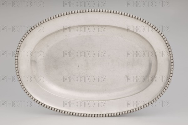 Vase with cover and platter, by Marcin Holke fl. ca. 1765–ca. 1792, goldsmith; tableware elements, vases; 18th century; Poland, Warsaw; vessel; height 20 cm, width 46 cm, depth 31.5 cm, An oval platter with a beaded rim rests against a neutral background; the platter is metallic with a matte silver-gray surface showing a few fine scratches and marks, and the beads around the edge are a slightly darker silver-gray, while the background appears a pale gray.