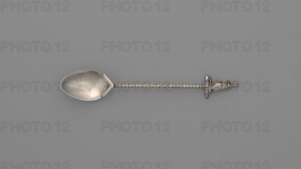 Souvenir spoon, subject: Paderewski, Ignacy Jan 1860–1941. Egg-shaped scoop with a pointed tip; twisted wire handle topped with a semi-plastic kangaroo. Souvenir from Paderewski's tour of Australia and New Zealand in 1904. Early 20th century before 1904. Place of origin: Australia, materials: cutlery/varia, length 12.5 cm, width 2.2 cm, weight 15 g., A metal spoon with a shiny silver bowl and a twisted silver handle ending in a small sculpted silver animal figure rests on a flat uniform gray background, showing shades of silver and gray throughout.