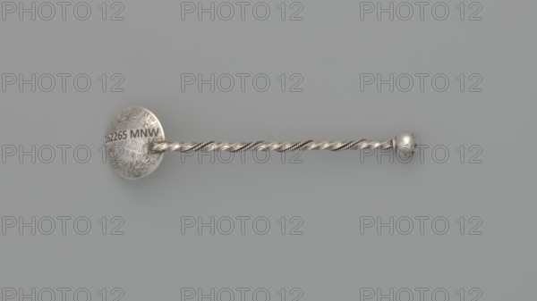 Souvenir spoon, Souvenir spoon with a scoop made from a 10-soldo coin obverse: profile of Pius IX and inscription PIVS IX PON MAX A XXII; reverse: inscription STATO PONTIFICO 50 R CMI and central laurel and oak wreath with 10 / SOLDI / 1868. Handle of twisted wire with a ball terminal. Materials: coin and wire. Date: 1868 coin, object dated to late 19th century. Place of origin: Italy. Function/type: cutlery souvenir spoon, varia. Dimensions: length 7.5 cm; width 1.8 cm; weight 5 g., A single metallic object lies horizontally against a smooth gray background, consisting of a round flattened disc on the left connected to a twisted rod that ends in a small spherical knob on the right; the object appears silver with areas of brighter and darker metallic sheen, and the background is a uniform light gray.