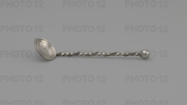 Souvenir spoon with a scoop made from a 10-soldo coin obverse: profile of Pius IX with inscription PIVS IX PON MAX A XXII; reverse: STATO PONTIFICO 50 R CMI and central laurel and oak wreath reading 10 / SOLDI / 1868. Handle of twisted wire with a ball terminal. Materials: coin metal and wire. Date: 1868 coin, late 19th century. Place of origin: Italy. Type: cutlery/souvenir spoon. Dimensions: length 7.5 cm, width 1.8 cm, weight 5 g. Maker: unknown., A metallic spoon-like object lies horizontally against a uniform gray background, showing a twisted handle with a braided pattern and a rounded knob at one end; the opposite end flares into an oval bowl with a raised rim and a bas-relief portrait; visible colors are shades of silver and gray.