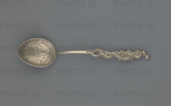 Souvenir spoon, Paderewski, Ignacy Jan 1860–1941, testament provenance, Japanese dragon motif. Silver souvenir spoon with a teardrop-shaped scoop decorated with an engraved stylized peony flower; Japanese inscription on the reverse, below it the Latin alphabet NAGASAKI. Narrow half-cylinder handle topped with a half-plastic Japanese dragon with three claws. Late 19th century, Asia, Far East. Cutlery, varia. Length 15 cm, width 3 cm, weight 15 g., A metallic spoon displayed against a muted gray background, with a shallow oval bowl etched with a floral, scalloped pattern and scalloped rim, a slender stem leading to an ornate handle carved with a textured, twisting dragon-like motif and raised decorative relief; visible colors include silver tones of the spoon and shades of gray in the background.
