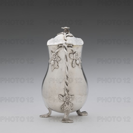 Jug, Holke, Marcin fl. ca. 1765–ca. 1792 goldsmith, tableware, flowers, before 1792, Poland, Warsaw; vessel; height 13.2 cm, width 10 cm, depth 6 cm, weight 215.8 g, A reflective pear-shaped metal container with a hinged lid stands on a flat surface against a neutral background. The container is silver in color with decorative floral appliqués and a twisted vertical ornament running down its front. The lid has a small flower-shaped finial and a curved, slightly domed top. The body tapers toward the top and widens at the lower section, resting on three ornate feet that curve outward and are decorated with leaf-like detailing. The background transitions from darker gray at the top to lighter gray near the bottom, and the surface beneath the object appears pale gray.
