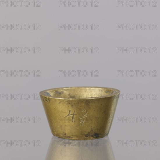 Gwicht; unknown creator; Szewczykowski, Roman 1849–1901; in the shape of a truncated cone; markings on the side engraved 43/4, inside 4, eagle; 57.84 g; 18th century; Europe; Germany; weight; height 2 cm; width 3.8 cm, A small metallic cup with a tapered cylindrical shape sits on a reflective surface; the cup is a muted gold color with darker patina spots and areas of wear, and its interior shows similar gold tones with subtle discoloration; the background is a smooth light gray, and the cup casts a faint reflection on the surface beneath it.