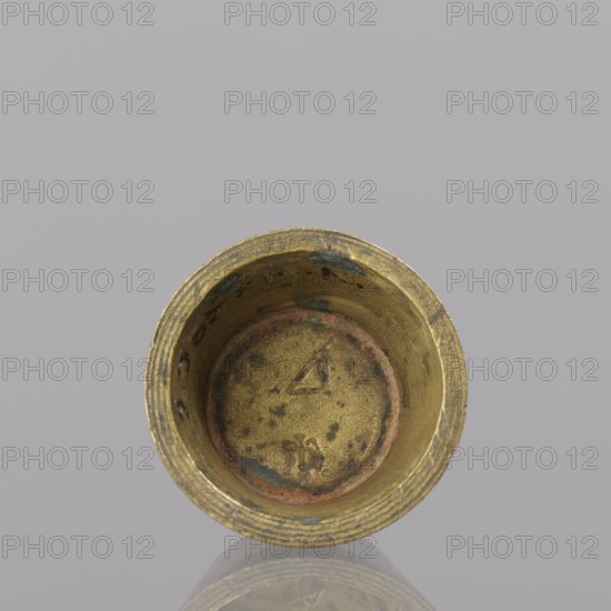 Gwicht, unknown creator; Szewczykowski, Roman 1849–1901. Measures and weights: in the shape of a truncated cone; markings on the side engraved 43/4, inside 4, eagle; 57.84 g; 18th century; Europe; Germany; height 2 cm; width 3.8 cm., A close-up top view of a cylindrical metal cup with a weathered golden surface showing patches of greenish-blue and reddish-brown discoloration, a textured rim with concentric grooves, and a slightly mottled interior base; the background is a smooth light gray.