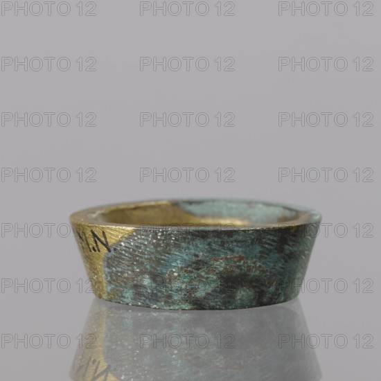 Gwicht, unknown, Szewczykowski, Roman 1849–1901; In the shape of a truncated cone, internal marking 2; weight 24.75 g; 18th century; Europe, Germany; height 1 cm; width 3.1 cm, A shallow, round metal dish with a worn, textured surface sits centered on a reflective surface; the dish shows a mix of greenish-blue patina and dark brown-green areas with patches of exposed gold-colored metal on the rim and interior, and the reflection below echoes these green, brown, and gold tones against a plain light gray background.